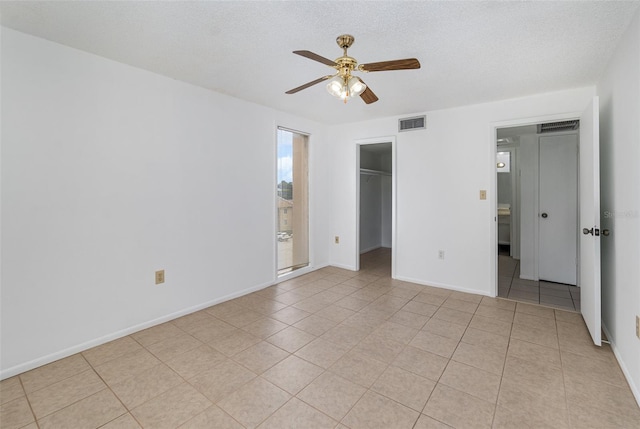 unfurnished bedroom with ceiling fan, a textured ceiling, a closet, and a spacious closet