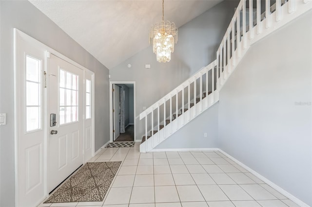 tiled foyer entrance with high vaulted ceiling and a chandelier