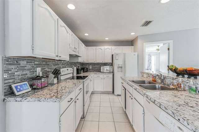 kitchen featuring white cabinets, white appliances, light tile flooring, sink, and tasteful backsplash