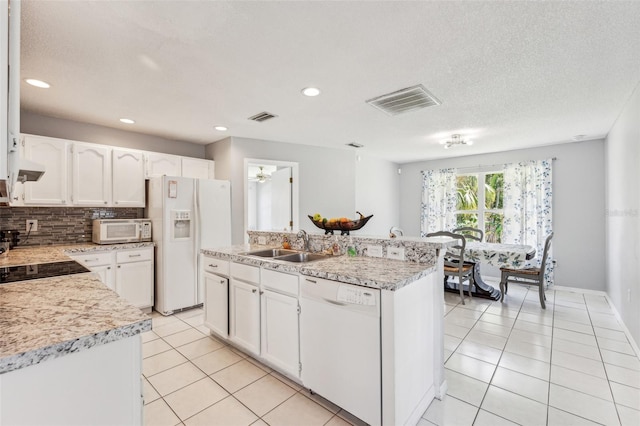 kitchen featuring a center island, white appliances, sink, and light tile flooring