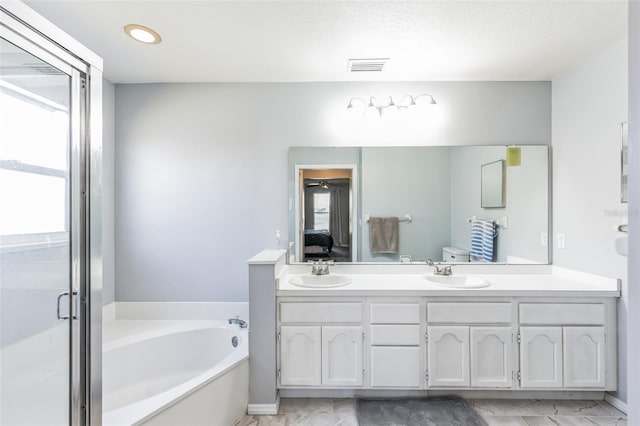 bathroom featuring double sink, tile flooring, oversized vanity, and a tub