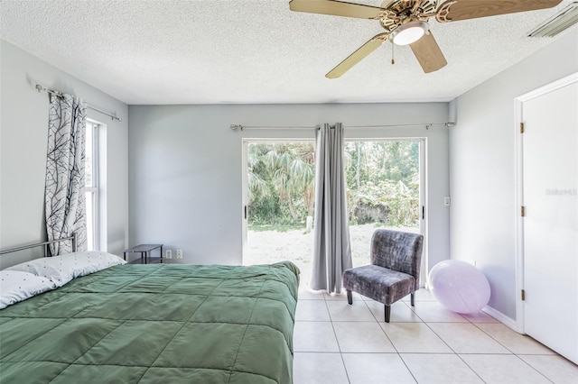 bedroom with a textured ceiling, ceiling fan, and light tile floors