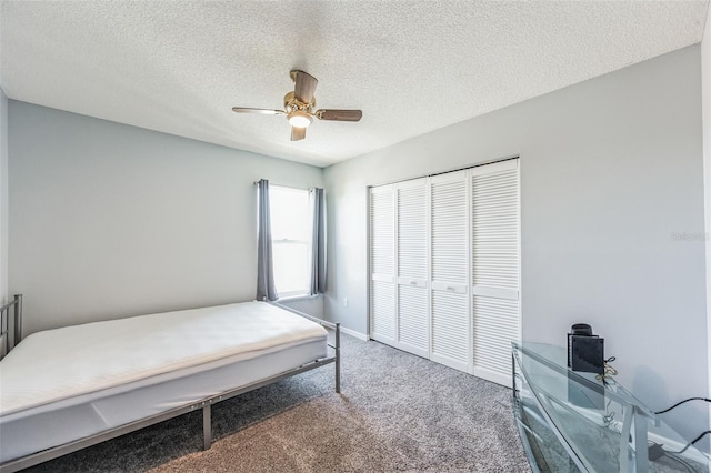 bedroom featuring a closet, ceiling fan, carpet floors, and a textured ceiling