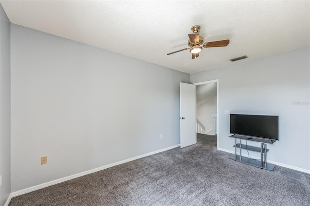 interior space with dark carpet, ceiling fan, and a textured ceiling