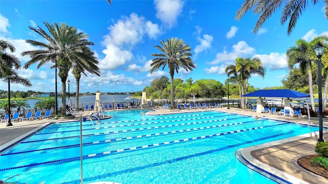 view of swimming pool with a water view and a patio area