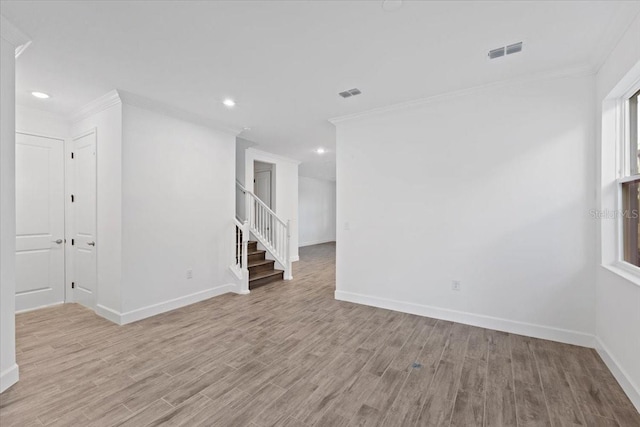 spare room with crown molding and light wood-type flooring