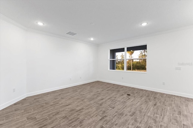 empty room with crown molding and hardwood / wood-style floors