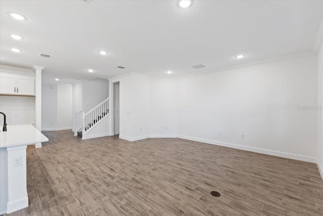 basement with hardwood / wood-style flooring and crown molding