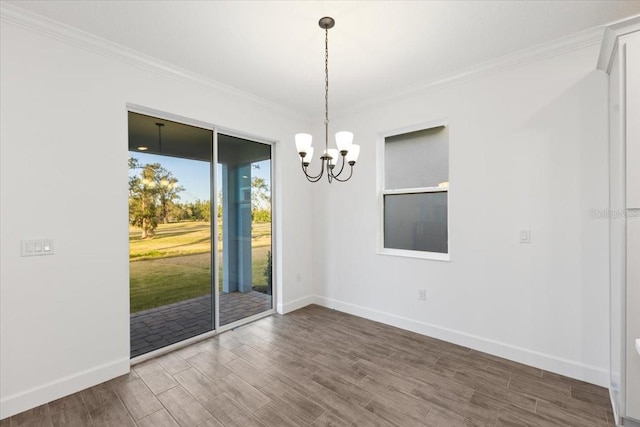 spare room featuring crown molding, a notable chandelier, and hardwood / wood-style flooring