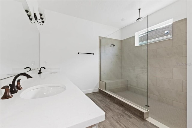 bathroom featuring hardwood / wood-style flooring, tiled shower, and sink