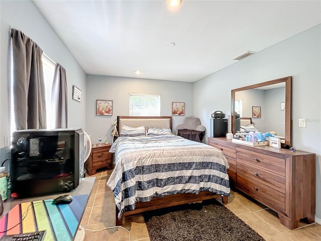 bedroom with light tile patterned floors and visible vents