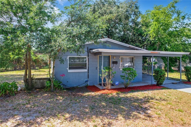 view of front of house with a carport and a front lawn