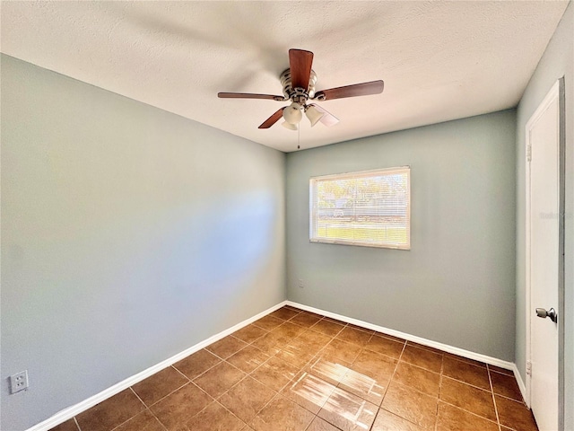 unfurnished room with a textured ceiling, a ceiling fan, and baseboards