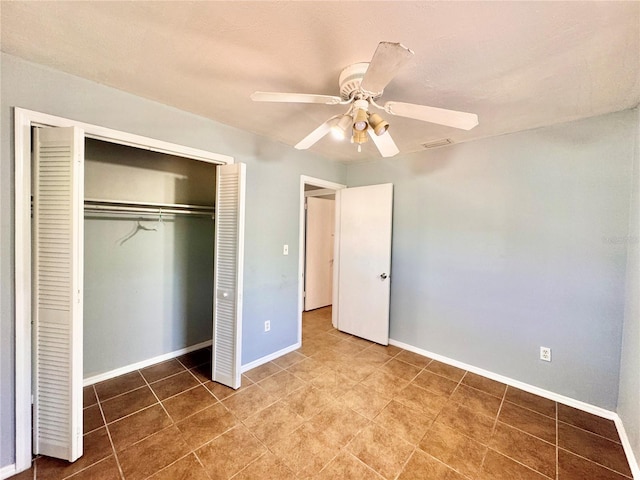 unfurnished bedroom with a ceiling fan, tile patterned flooring, baseboards, and a closet