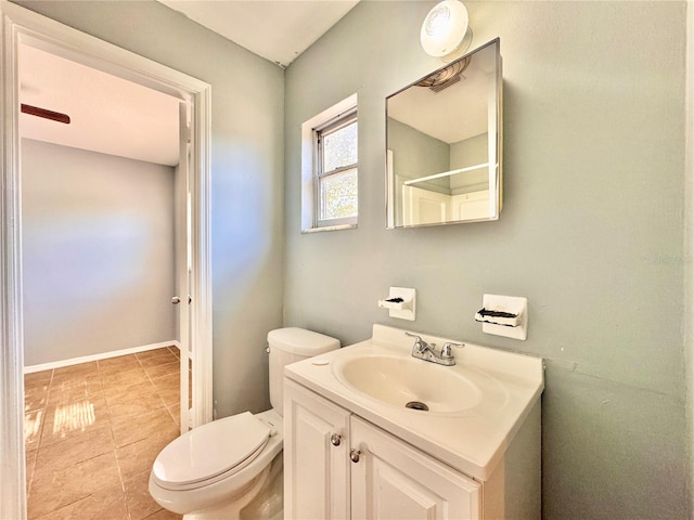 bathroom featuring toilet, tile patterned flooring, baseboards, and vanity