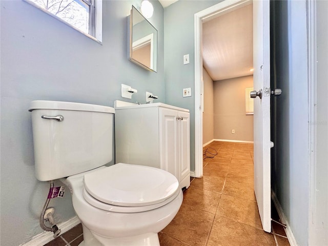 bathroom featuring toilet, baseboards, and tile patterned floors