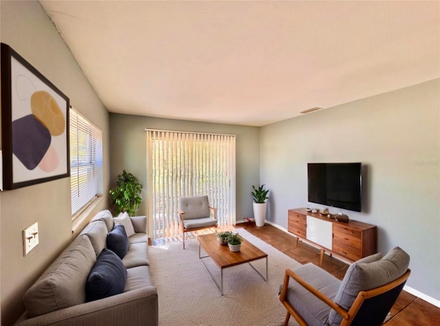 living room featuring baseboards and visible vents