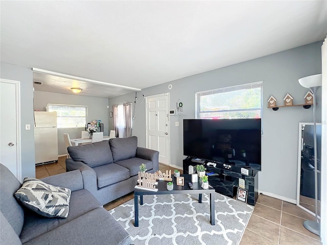 living area with visible vents, baseboards, and tile patterned floors