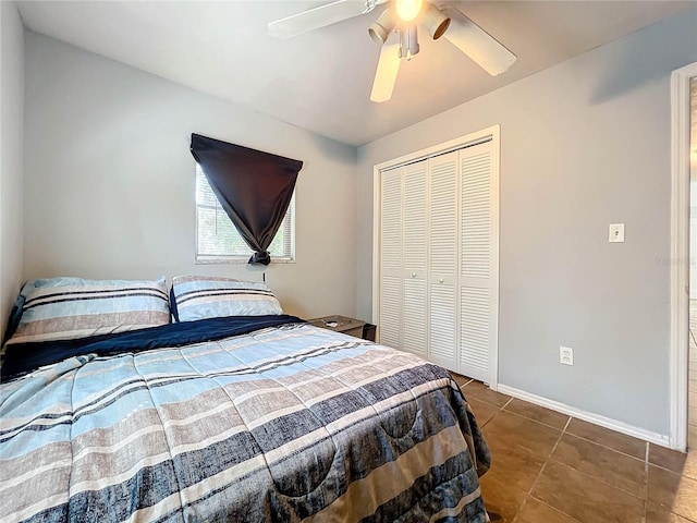 tiled bedroom with a ceiling fan, baseboards, and a closet