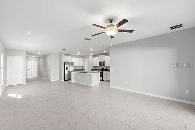 unfurnished living room featuring ceiling fan and light tile flooring