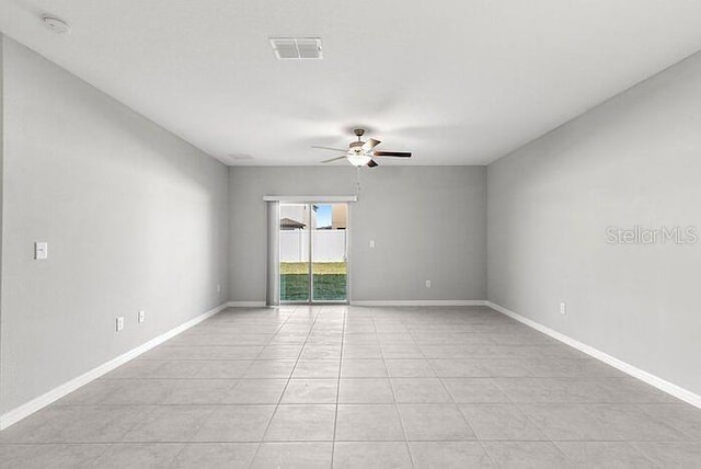 empty room with ceiling fan and light tile floors