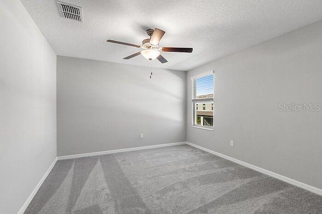 carpeted spare room with a textured ceiling and ceiling fan