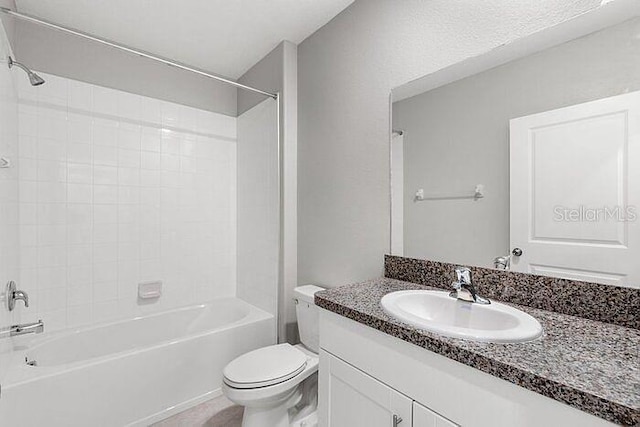 full bathroom with vanity with extensive cabinet space, toilet, and tiled shower / bath