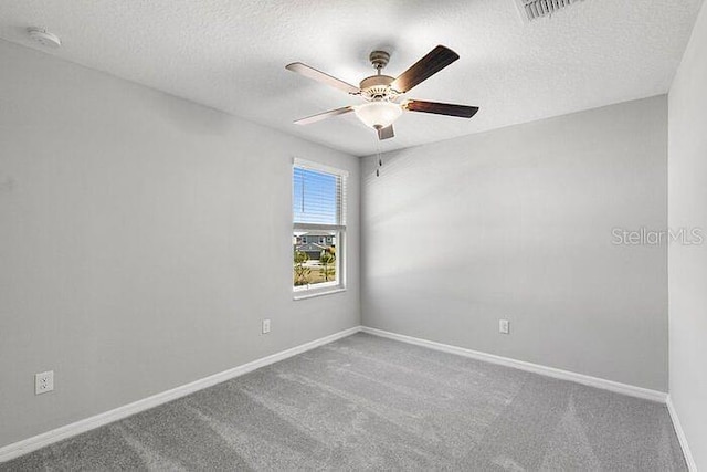 empty room featuring ceiling fan, carpet flooring, and a textured ceiling