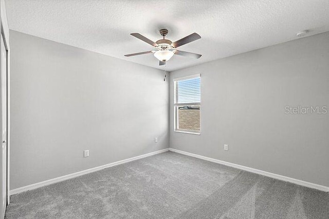 carpeted empty room featuring ceiling fan and a textured ceiling