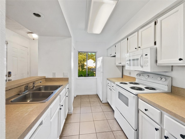 kitchen with light tile floors, white cabinets, white appliances, and sink