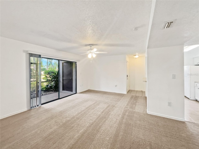 spare room with a textured ceiling, ceiling fan, and light carpet