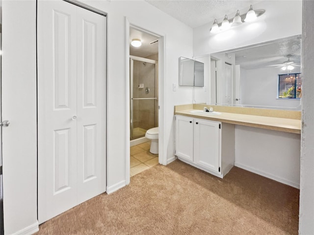 bathroom featuring tile flooring, ceiling fan, large vanity, toilet, and a shower with shower door