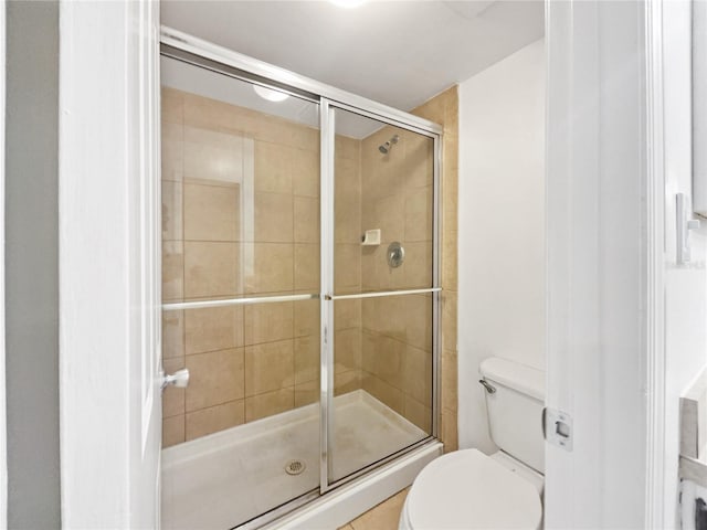 bathroom featuring walk in shower and toilet