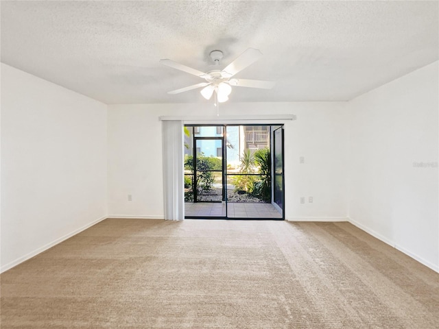 spare room featuring light colored carpet, ceiling fan, and a textured ceiling