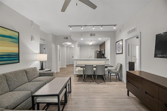 living room with sink, light hardwood / wood-style flooring, ceiling fan, and track lighting