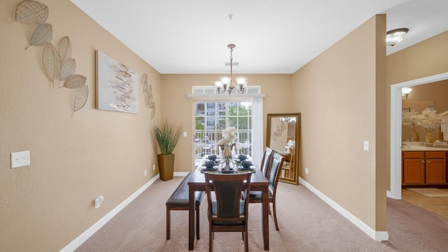 carpeted dining space featuring an inviting chandelier