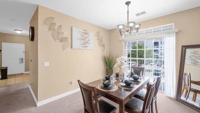 dining room with a chandelier and light carpet