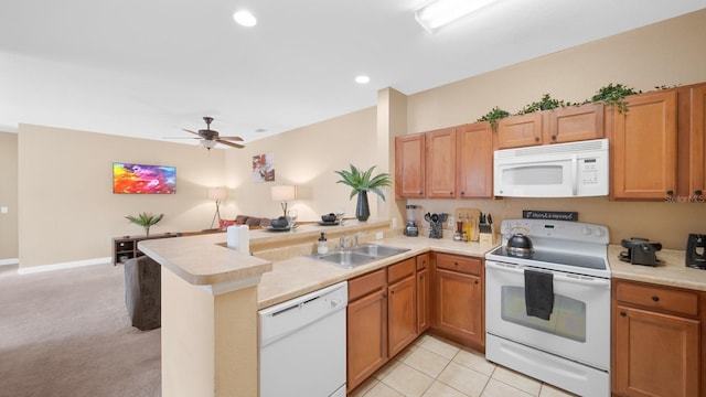 kitchen with ceiling fan, white appliances, sink, kitchen peninsula, and light colored carpet