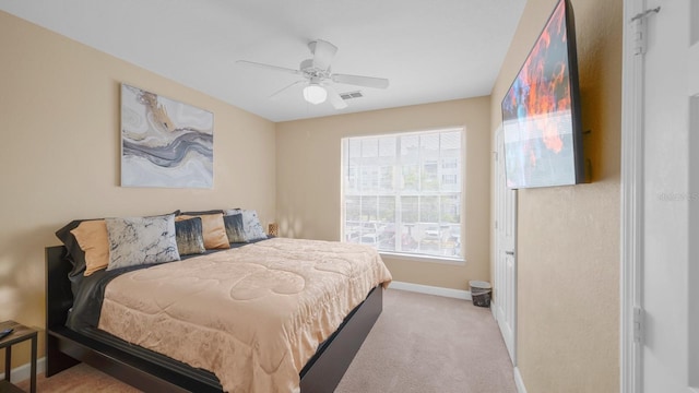 bedroom with ceiling fan and light carpet