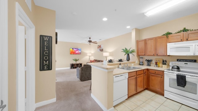 kitchen featuring ceiling fan, light carpet, white appliances, sink, and kitchen peninsula