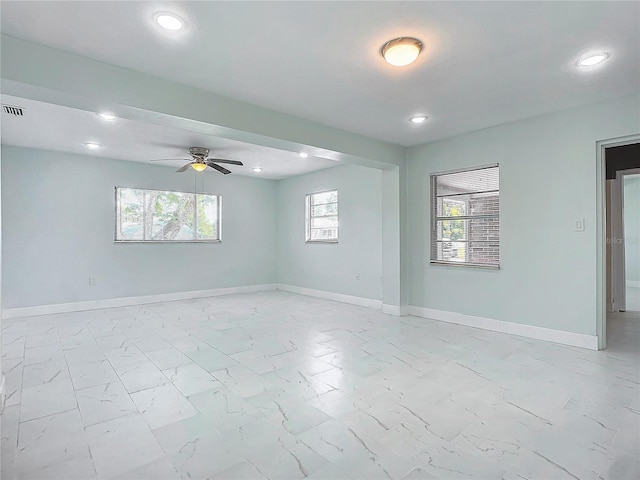 tiled empty room with a wealth of natural light and ceiling fan