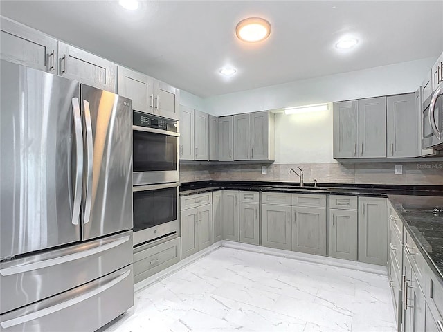 kitchen with gray cabinetry, appliances with stainless steel finishes, light tile floors, sink, and tasteful backsplash