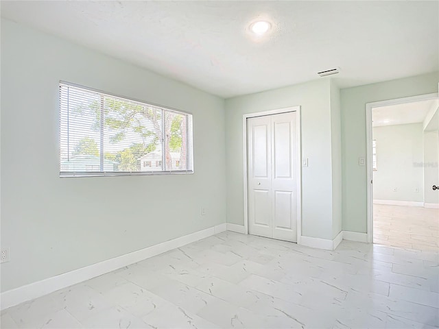 unfurnished bedroom with a closet and light tile floors