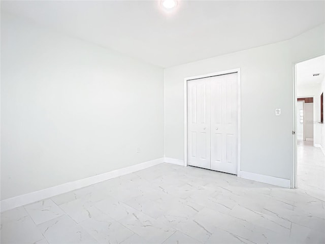 unfurnished bedroom with a closet and light tile floors