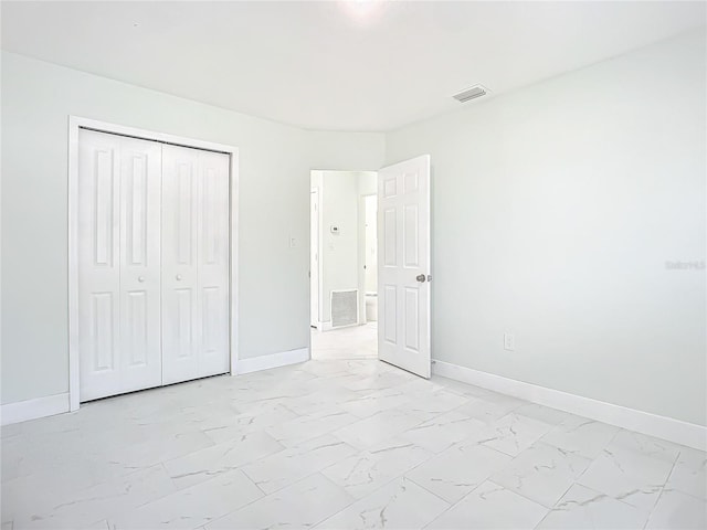 unfurnished bedroom with a closet and light tile floors