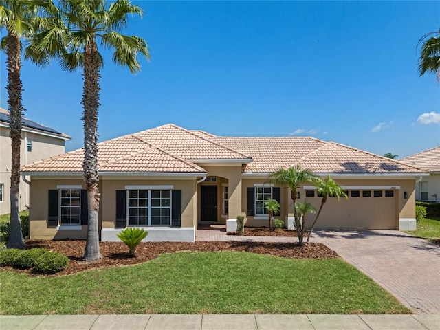 mediterranean / spanish-style home featuring a garage and a front yard