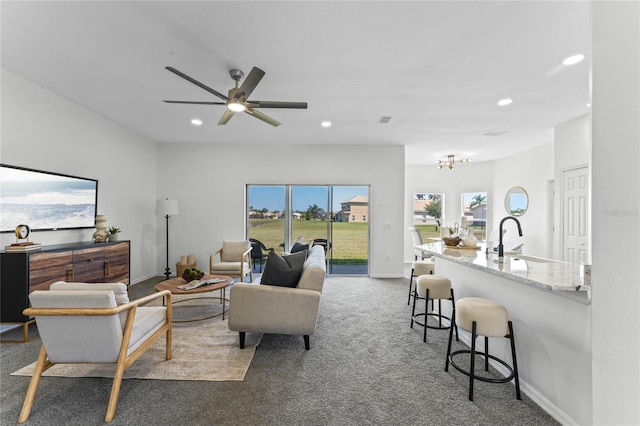 carpeted living room with sink and ceiling fan