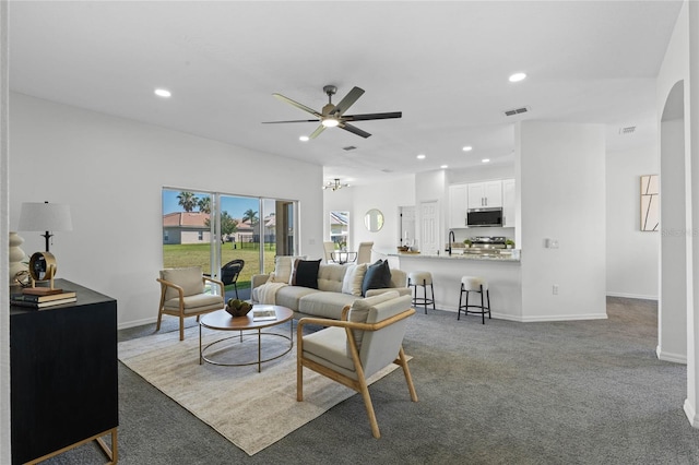 living room featuring sink, ceiling fan, and carpet flooring