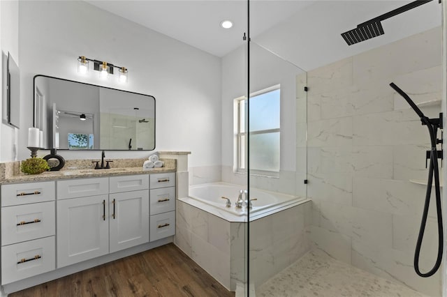 bathroom featuring hardwood / wood-style floors, vanity, and shower with separate bathtub