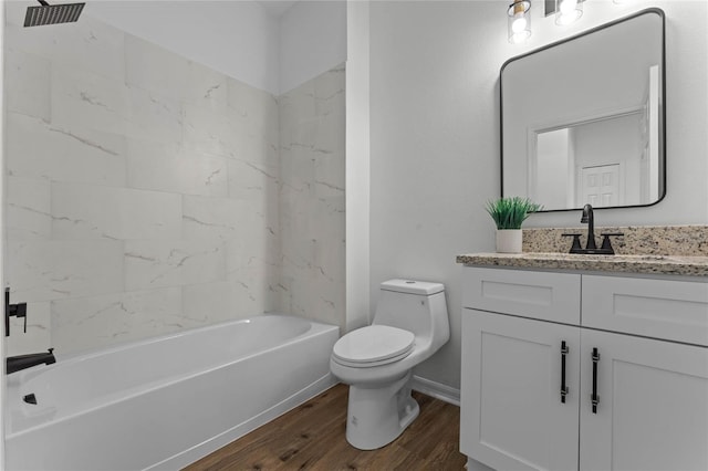 full bathroom with hardwood / wood-style flooring, tiled shower / bath, toilet, and vanity